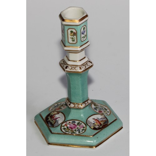 298 - A pair of Berlin hexagonal candlesticks, of silver shape, decorated in polychrome with landscape vig... 