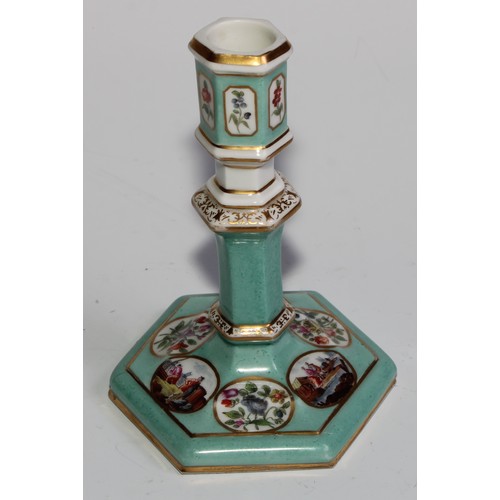 298 - A pair of Berlin hexagonal candlesticks, of silver shape, decorated in polychrome with landscape vig... 