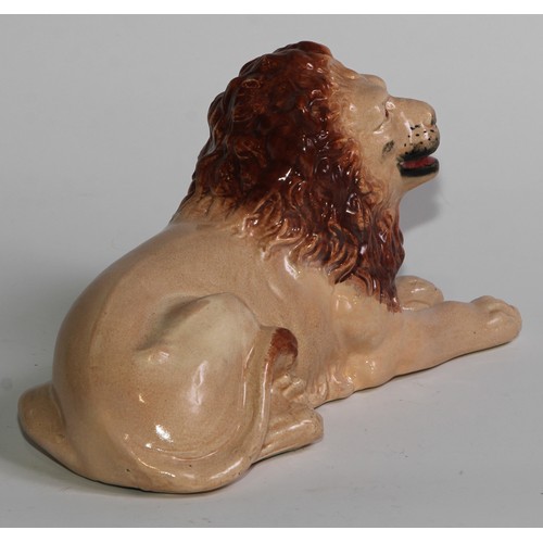 103 - An English pottery lion, modelled recumbent and slip cast, 21cm long