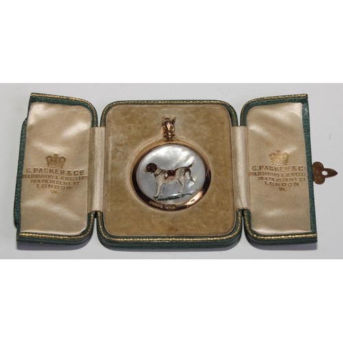 1503 - An early 20th century 9ct gold mounted rock crystal pendant, carved and painted with a dog, on a mot... 