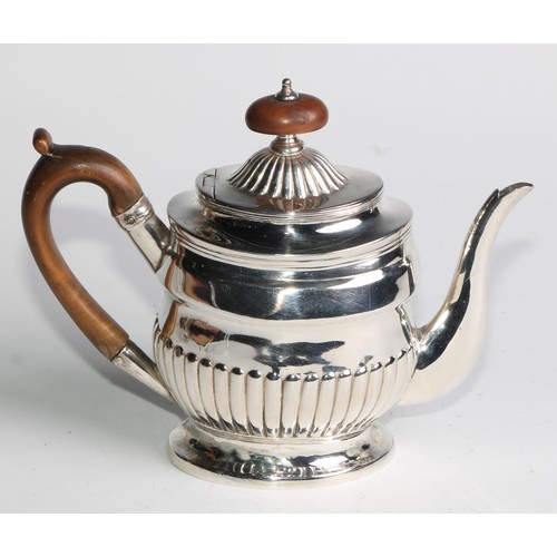 924 - A George III silver half-fluted bachelor's teapot, hinged cover, scroll-capped handle, skirted base,... 