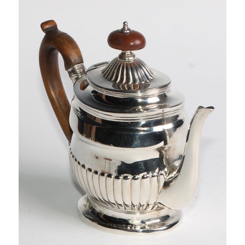 924 - A George III silver half-fluted bachelor's teapot, hinged cover, scroll-capped handle, skirted base,... 