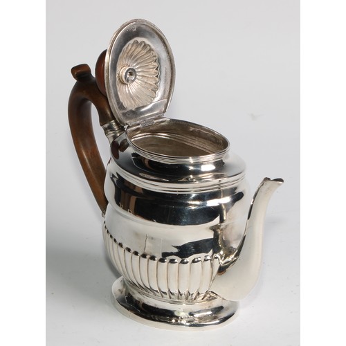 924 - A George III silver half-fluted bachelor's teapot, hinged cover, scroll-capped handle, skirted base,... 