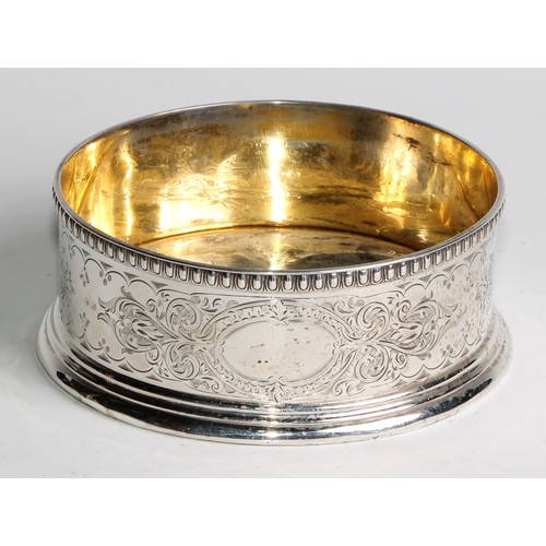 1111 - A Victorian silver wine coaster, the gallery and gilt interior engraved with leafy strapwork, egg-an... 