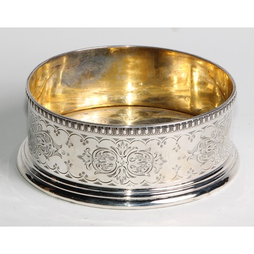 1111 - A Victorian silver wine coaster, the gallery and gilt interior engraved with leafy strapwork, egg-an... 