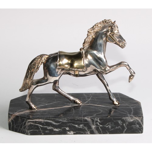 870 - A Continental parcel-gilt silver coloured metal model, of a horse, prancing, filled, canted rectangu... 