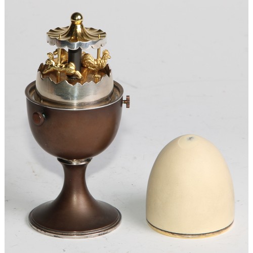 1198 - Anthony Gordon Elson (Bn.1935)	- an Elizabeth II silver surprise egg, enclosing a gilt carousel, 11c... 