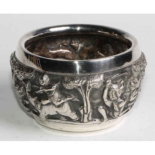 860 - A Burmese silver circular bowl, repousse chased with hunting scenes, the base with a bird in a tree,... 