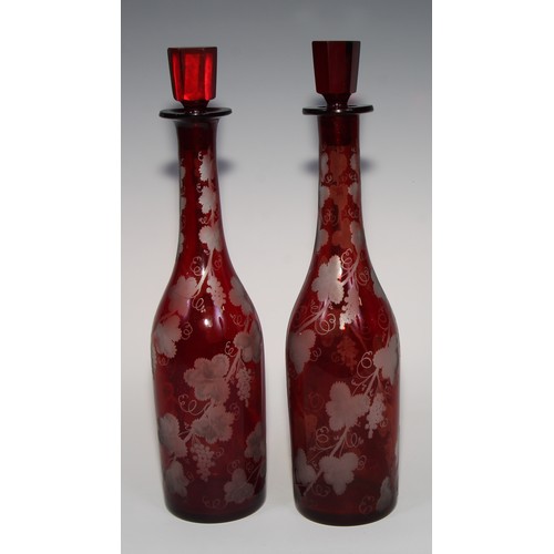 323 - A pair of Bohemian ruby flashed glass decanters, etched with spiralling fruiting vine, 35cm high, c.... 