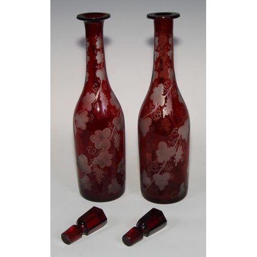 323 - A pair of Bohemian ruby flashed glass decanters, etched with spiralling fruiting vine, 35cm high, c.... 