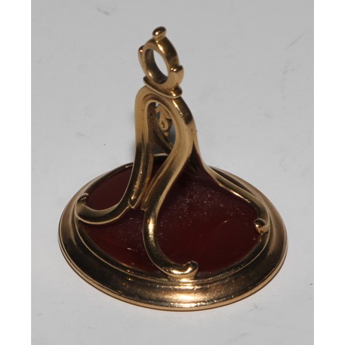 2141 - A 19th century gold coloured metal seal fob, the carnelian matrix with armorial intaglio, 3cm wide