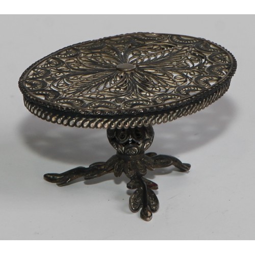 878 - A Continental silver filigree miniature oval tripod centre table, 4.5cm wide, early 20th century