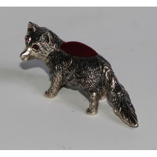 1075 - A sterling silver novelty pin cushion, as a fox, ruby eyes, 6cm long