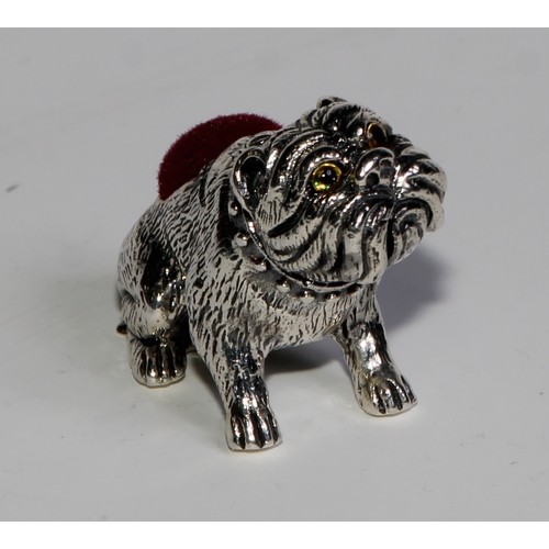 1074 - A sterling silver novelty pin cushion, as a bulldog, glass eyes, 3.5cm long