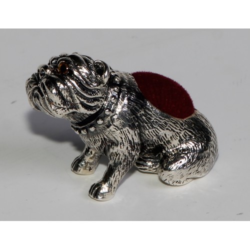 1074 - A sterling silver novelty pin cushion, as a bulldog, glass eyes, 3.5cm long