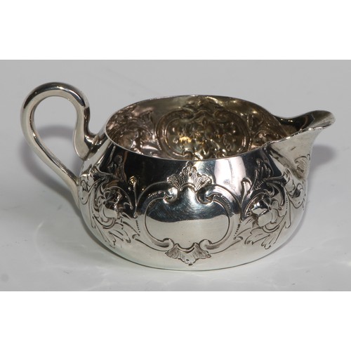 1088 - A Victorian silver cream jug, chased with flowers, stiff leaves and C-scrolls, 9cm long, Horace Wood... 