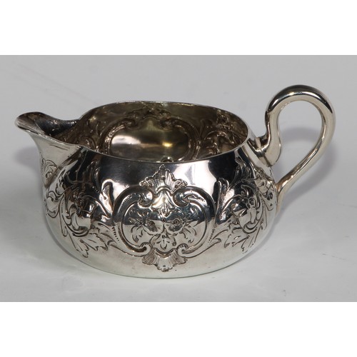 1088 - A Victorian silver cream jug, chased with flowers, stiff leaves and C-scrolls, 9cm long, Horace Wood... 