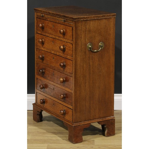 2659 - An Arts & Crafts period oak collector’s specimen chest, rectangular top above a slide and six long d... 