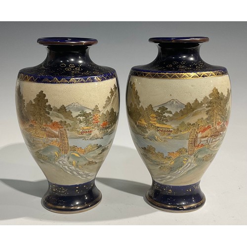 473 - A pair of Japanese satsuma baluster vases, decorated with traditional landscape and bird panels, blu... 