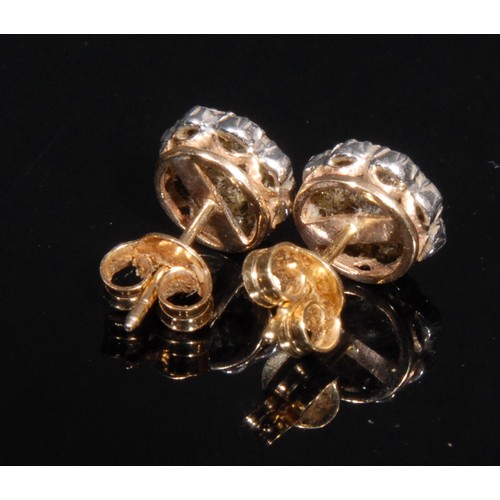 1426 - A pair of diamond flower head cluster ear studs, stamped '750' for 18ct gold, set with nine round br... 