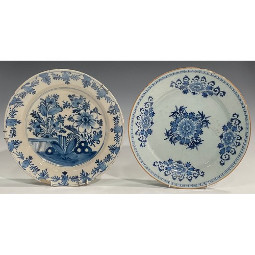 300 - A pair of Delftware chargers, boldly decorated in underglaze blue with flowers, 34.5cm diameter; oth... 