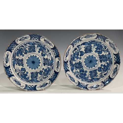 300 - A pair of Delftware chargers, boldly decorated in underglaze blue with flowers, 34.5cm diameter; oth... 