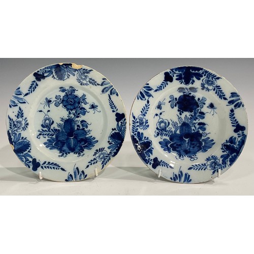 300 - A pair of Delftware chargers, boldly decorated in underglaze blue with flowers, 34.5cm diameter; oth... 