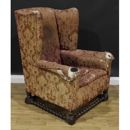 2568 - A substantial early 20th century wing chair, spirally turned and blocked supports and stretchers, 11... 