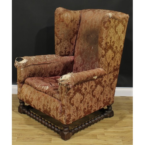 2568 - A substantial early 20th century wing chair, spirally turned and blocked supports and stretchers, 11... 