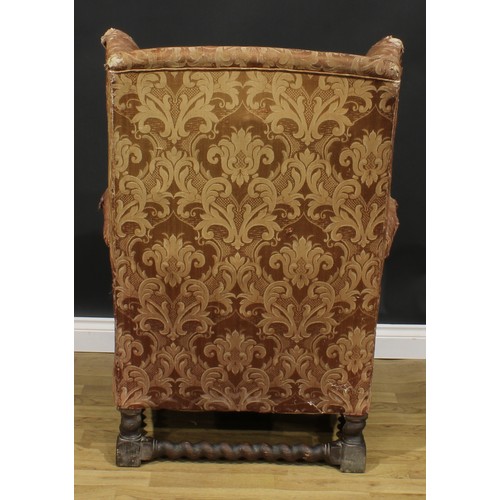 2568 - A substantial early 20th century wing chair, spirally turned and blocked supports and stretchers, 11... 