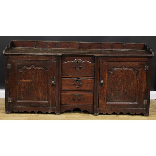 2004 - An 18th century oak low dresser, rectangular top with six small drawers above a pair of raised and f... 