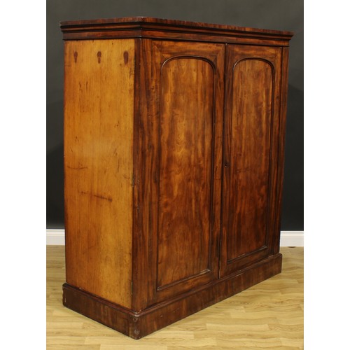 2587 - A Victorian mahogany press cupboard, outswept cornice above a pair of panel doors, enclosing four sl... 