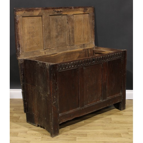 1569 - A 17th century oak blanket chest, hinged top, nulled frieze, three panel front, 74cm high, 115cm wid... 