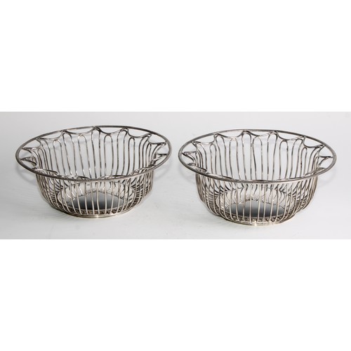 1028 - A pair of George V Neo-Classical Revival silver circular wirework bread or cake baskets, crested, 21... 