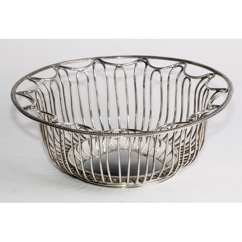 1028 - A pair of George V Neo-Classical Revival silver circular wirework bread or cake baskets, crested, 21... 