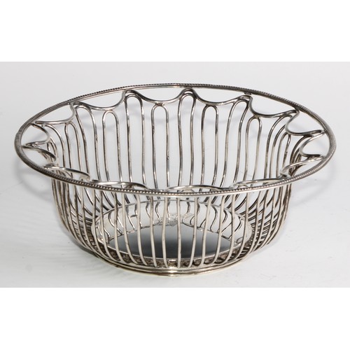 1028 - A pair of George V Neo-Classical Revival silver circular wirework bread or cake baskets, crested, 21... 