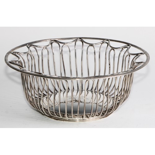 1028 - A pair of George V Neo-Classical Revival silver circular wirework bread or cake baskets, crested, 21... 