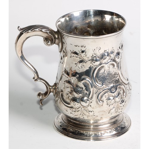 1085 - A Victorian silver bell shaped mug, chased with flowers and C-scrolls, acanthus capped double-scroll... 