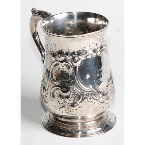 1085 - A Victorian silver bell shaped mug, chased with flowers and C-scrolls, acanthus capped double-scroll... 