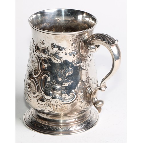 1085 - A Victorian silver bell shaped mug, chased with flowers and C-scrolls, acanthus capped double-scroll... 