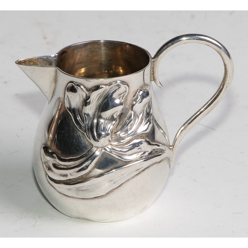 1030 - A pair of German Art Nouveau silver sparrow beak cream jugs, applied with stylised lilies in whiplas... 