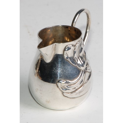 1030 - A pair of German Art Nouveau silver sparrow beak cream jugs, applied with stylised lilies in whiplas... 