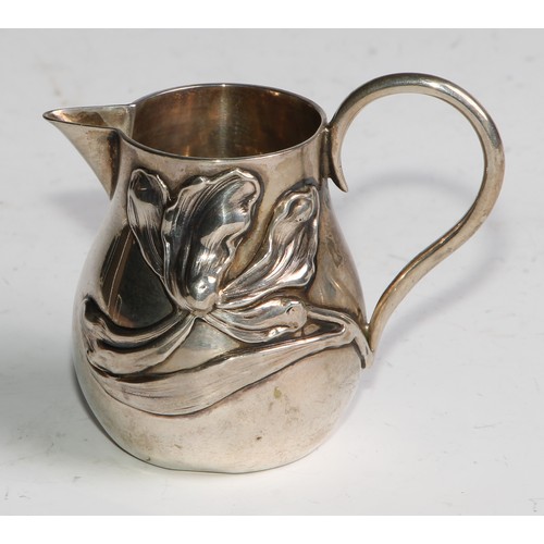 1030 - A pair of German Art Nouveau silver sparrow beak cream jugs, applied with stylised lilies in whiplas... 