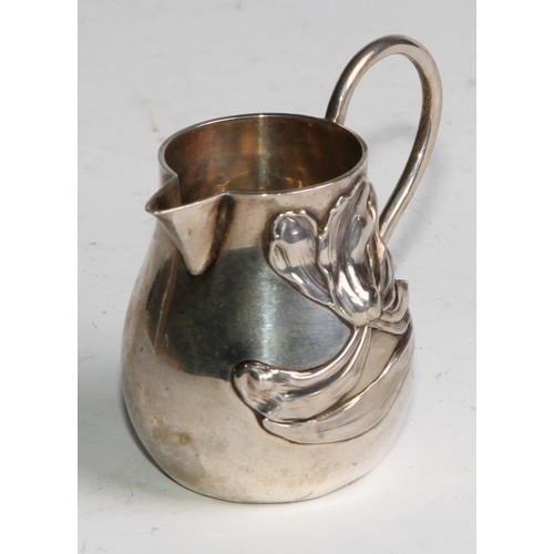 1030 - A pair of German Art Nouveau silver sparrow beak cream jugs, applied with stylised lilies in whiplas... 