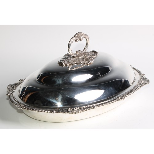 933 - A George III silver oval entree dish, of Irish interest, the ogee cover with acanthus C-scroll loop ... 