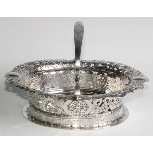 894 - A George II Revival silver oval table centre basket, arched handle, the shaped border pierced and ch... 