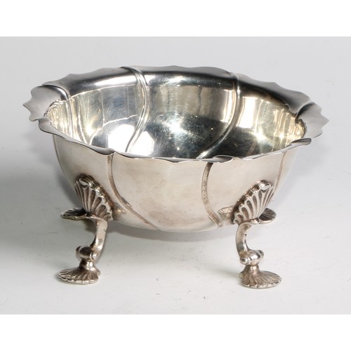 1123 - An 18th century silver spirally fluted bowl, possibly Colonial, shaped rim, shell shaped pad feet, 1... 