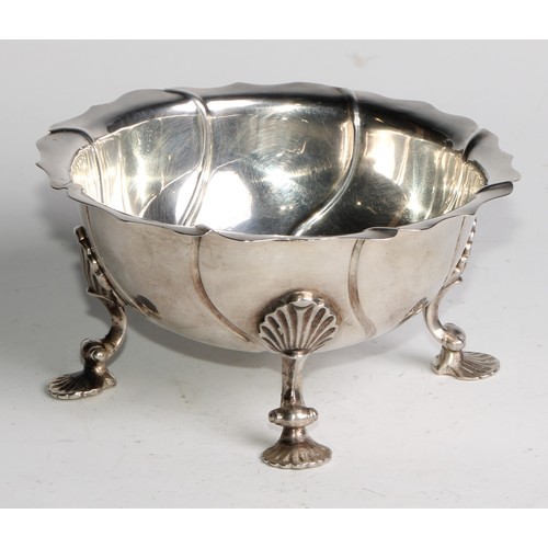 1123 - An 18th century silver spirally fluted bowl, possibly Colonial, shaped rim, shell shaped pad feet, 1... 