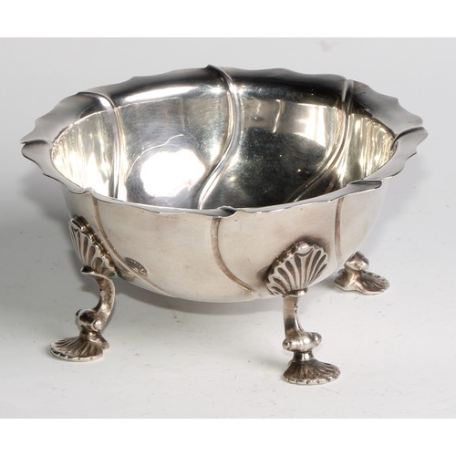 1123 - An 18th century silver spirally fluted bowl, possibly Colonial, shaped rim, shell shaped pad feet, 1... 