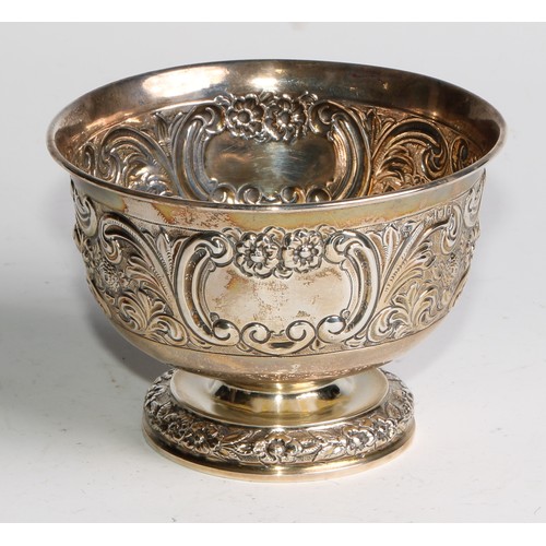 1037 - A pair of Victorian silver pedestal bowls, chased with flowers and scrolling leaves, centred by vaca... 